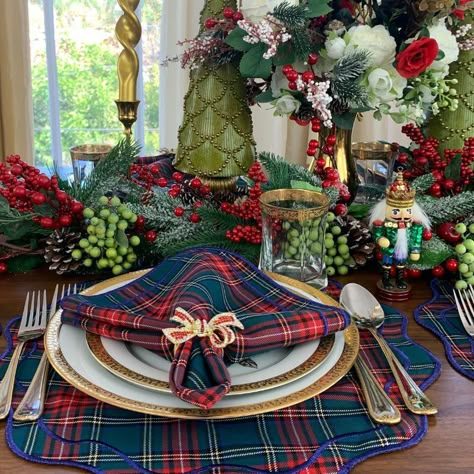 Contemporary dining space with poinsettia plates, matte black chairs, wood table, sunlight, festive holiday greenery.