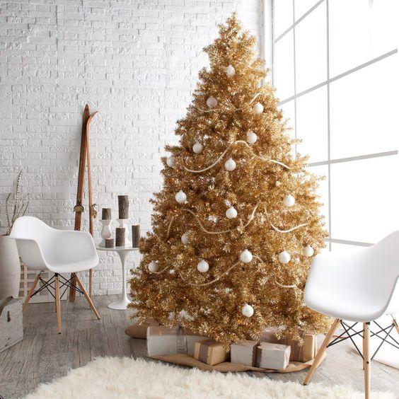 Dining room table decorated with gold charger plates, crystal glasses, and warm string lighting overhead.
