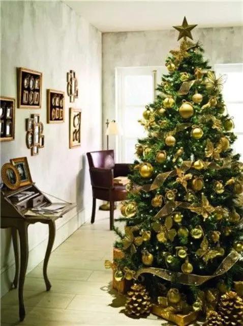 Foyer entryway featuring a wooden bench with gold velvet pillows, brass lanterns, and holiday wreath.