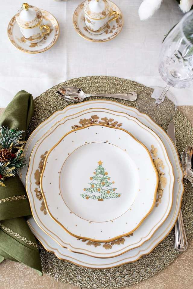 Formal dining room, gold embossed china, velvet runner, crystal chandelier lighting, high-end festive atmosphere.