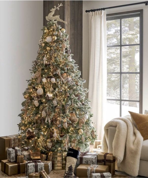 Mantlepiece with scalloped felt garland, white stockings, wooden accents, warm fairy lights.