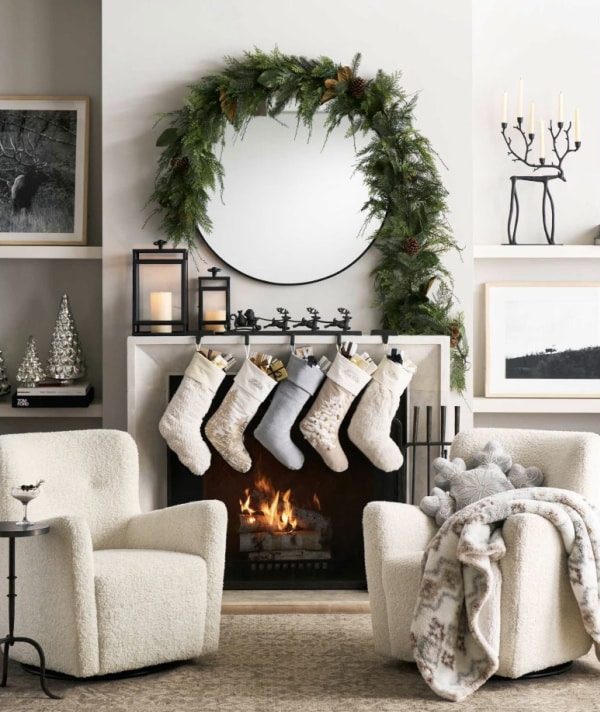 Fireplace mantle with large ornate mirror, crystal ornaments, silver candles, warm reflection.