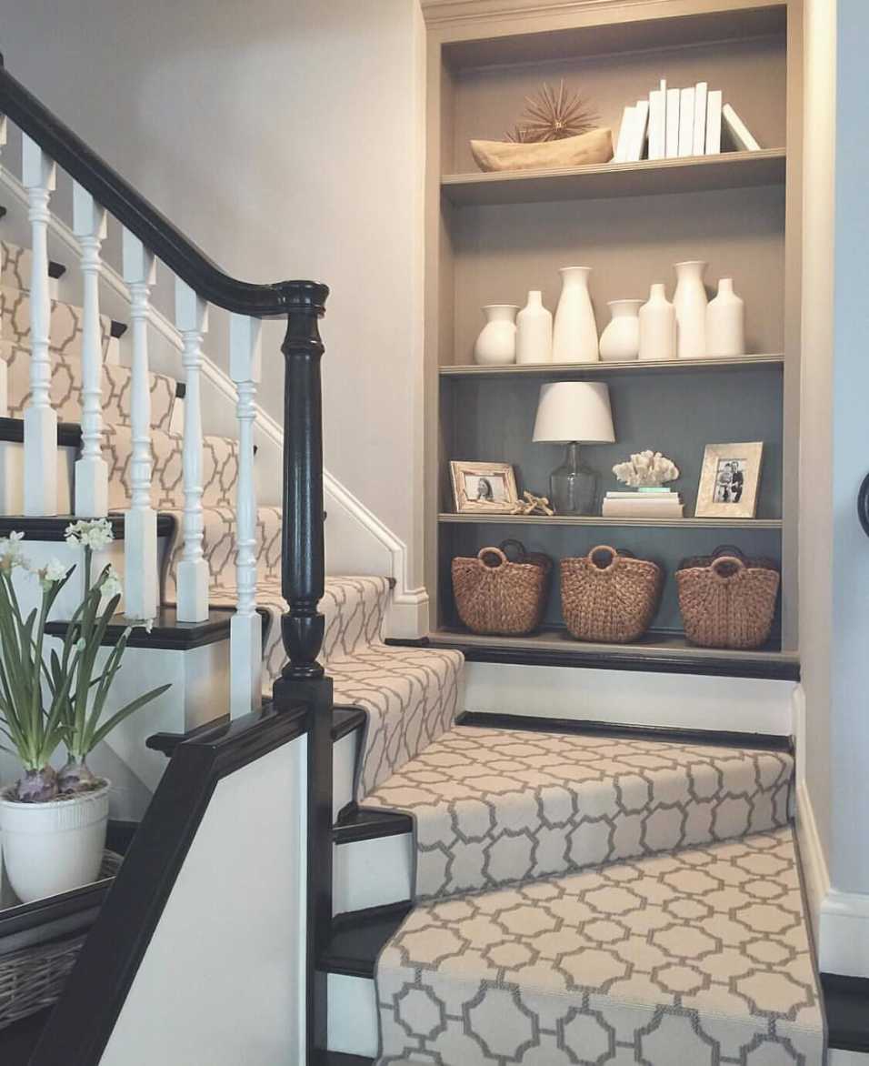 Elegant stair landing with velvet chaise, marble table, and crystal chandelier, luxurious feel