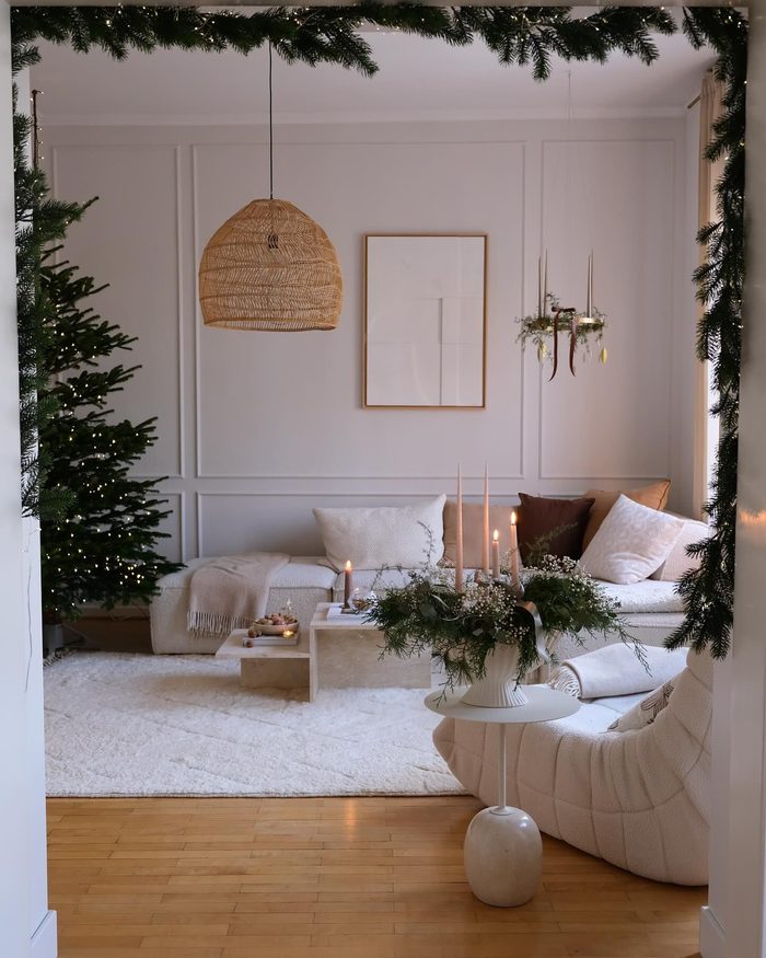 Entryway console table styled with vintage brass candlesticks and mercury glass ornaments christmas decorating trends.