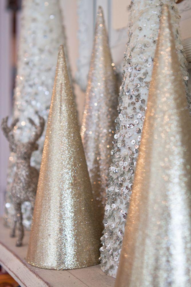 Stone fireplace mantel styled with gold christmas decor, cedar branches, and antique gold candlesticks.