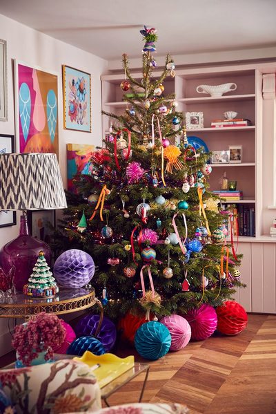 Modern black fireplace styled with white stockings and crisp green pine for christmas decorating trends.