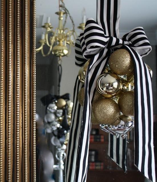 China cabinet with gold christmas decor, crystal glassware, and gold-trimmed plates.