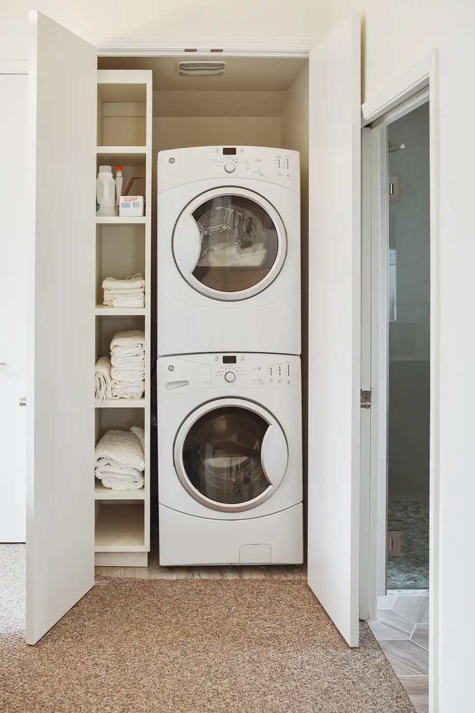 Small French Country apartment laundry room with patterned ceramic floor tiles white beadboard brass rack