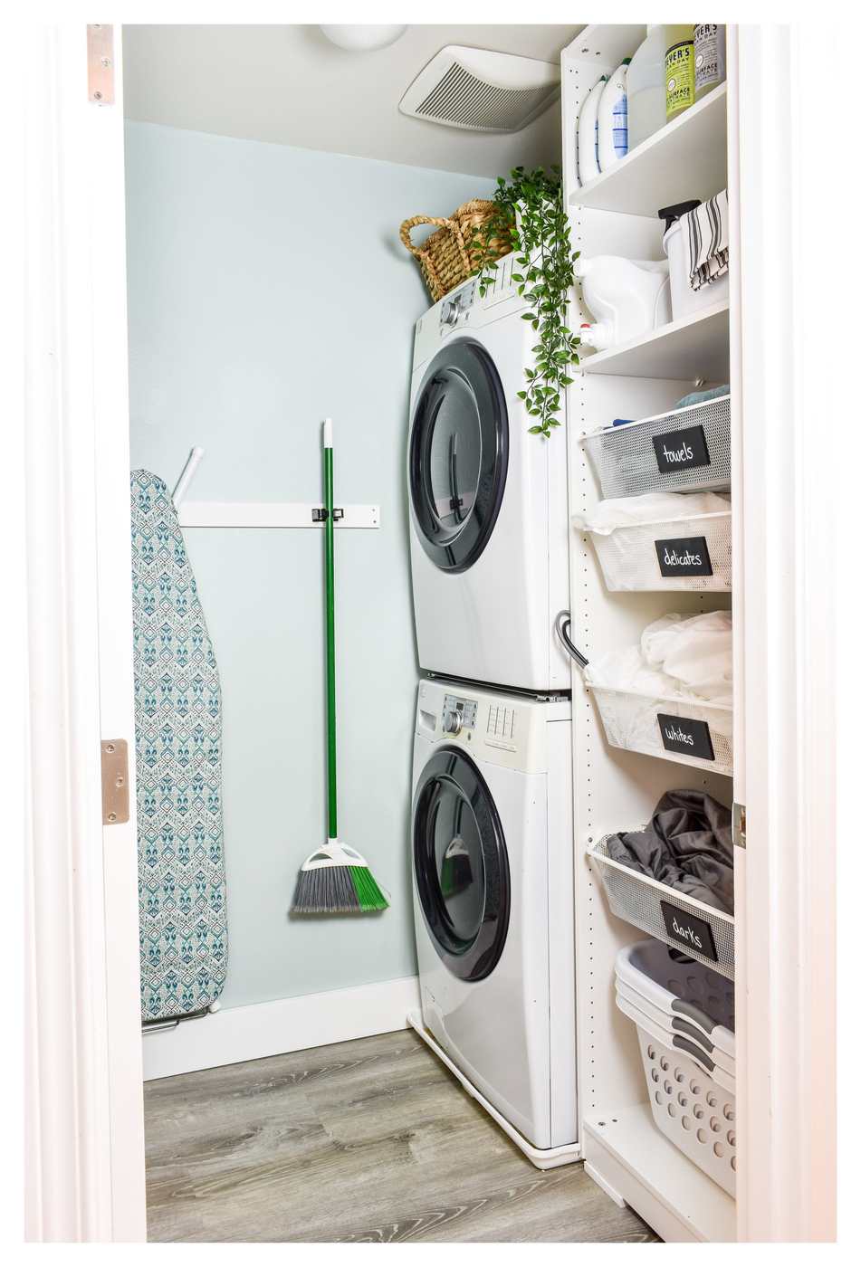 Parisian apartment laundry nook featuring picture frame wall molding, marble counter, brass swan neck faucet.