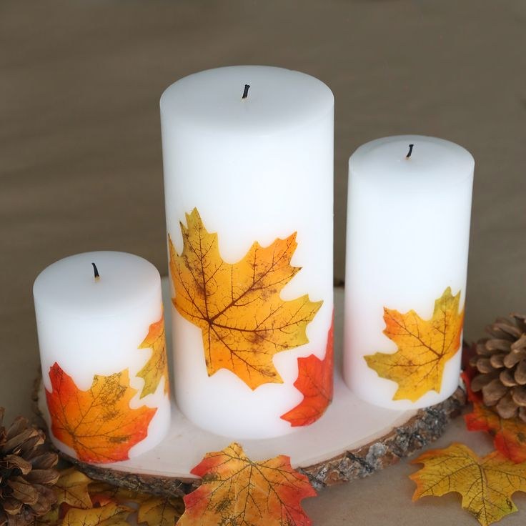 Dining room sideboard, three pillar candles with leaf decoupage, copper accents, warm lighting