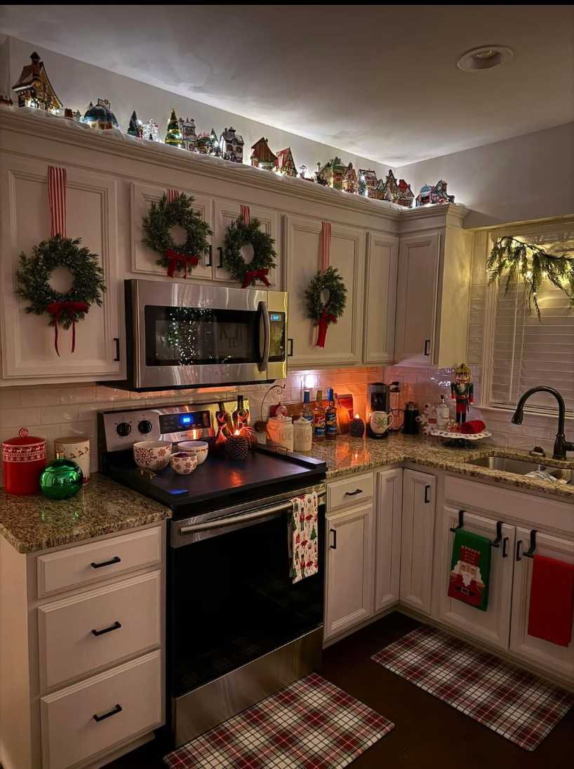 Small balcony rail wrapped with red and white striped candy‑cane LED lights, framed by potted evergreen branches.