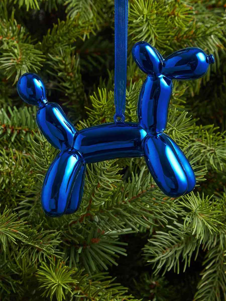Snowy white christmas tree featuring an iridescent pearl balloon elephant ornament with subtle pastel reflections.