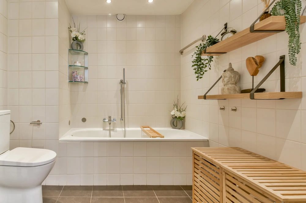 Unfilled raw travertine stone walls floating wood shelf soft flax linen window drape amber warm light.
