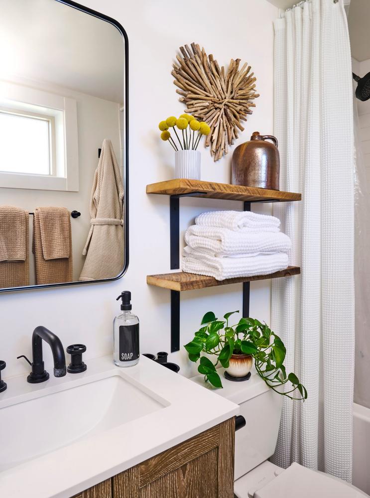 Rustic bathroom terracotta brick wall antique brass wall sconces warm glowing filament bulb timber vanity.