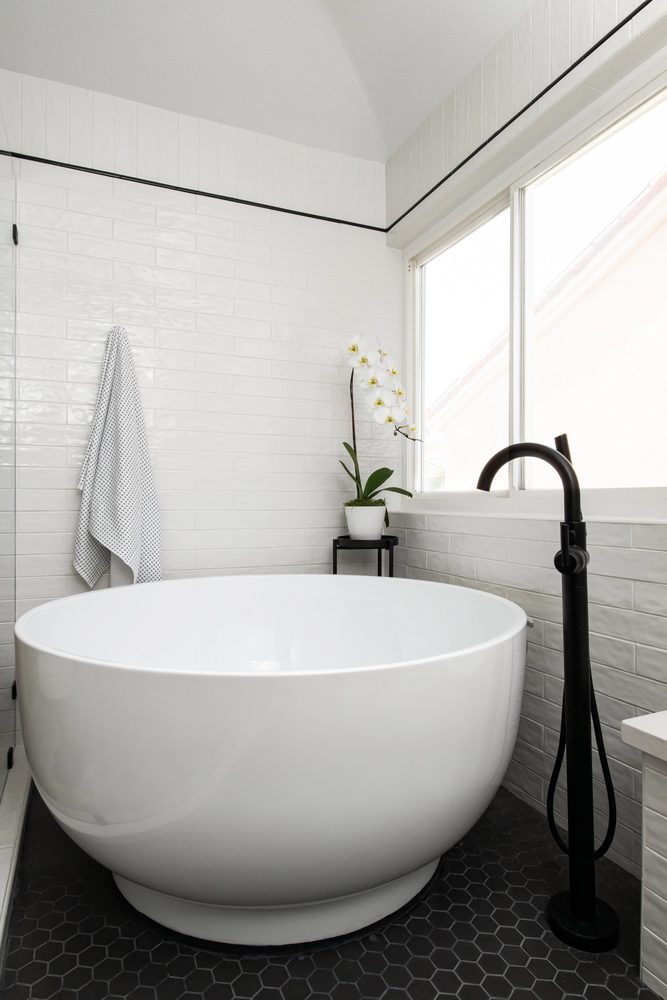Spacious open-concept wet room with a rain showerhead and glass partition wall.