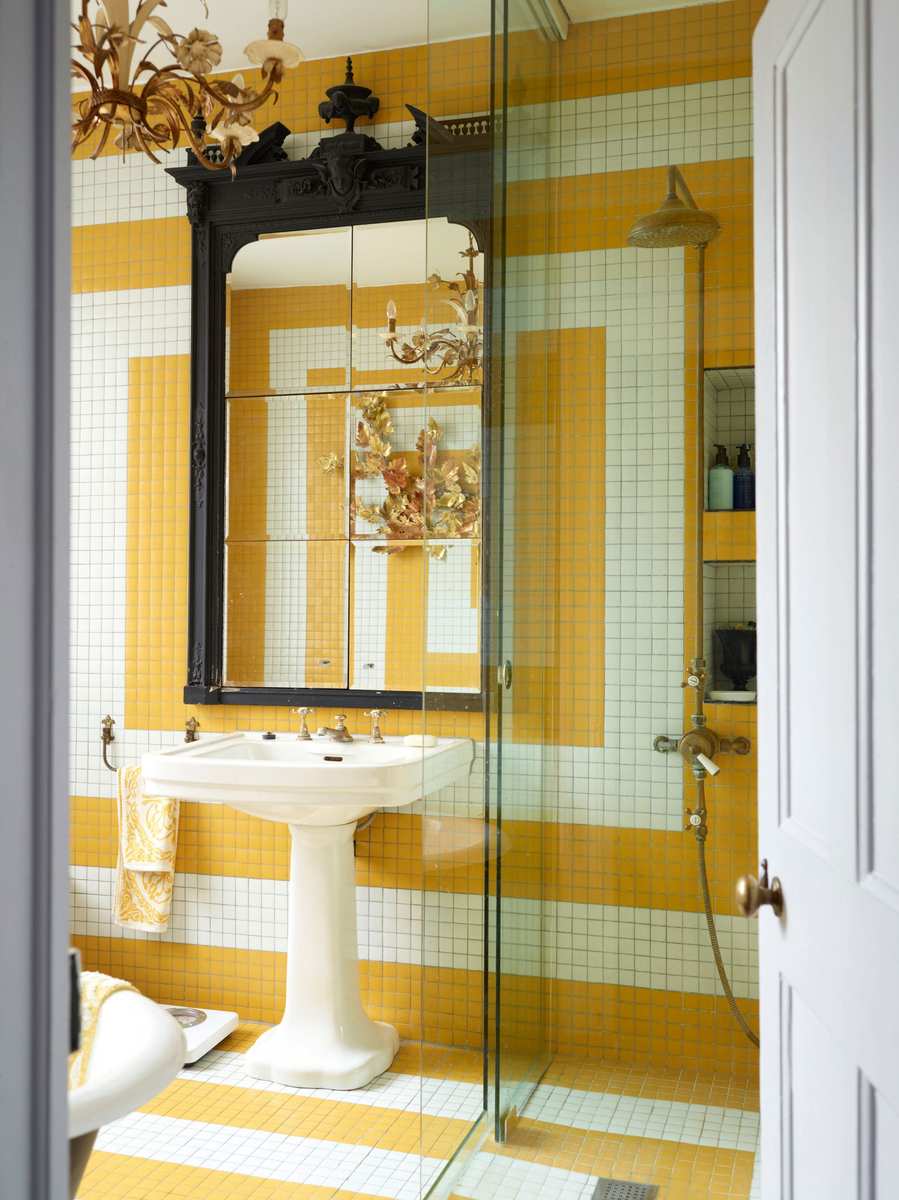Ultra-modern bathroom with a large backlit rectangular mirror, concrete walls, and stone sink.