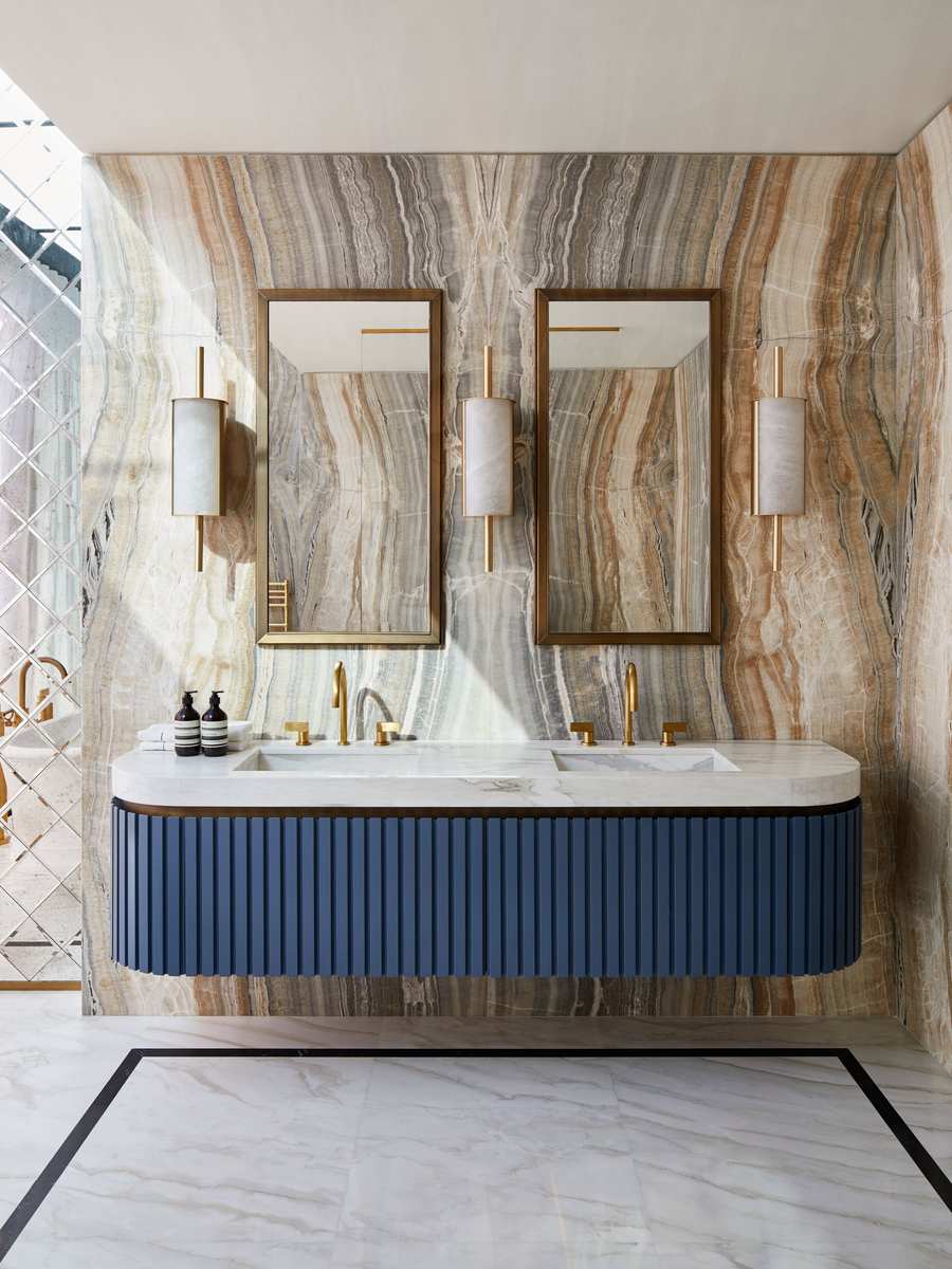 Industrial bathroom with a black steel frame mirror, terracotta tile, and concrete vanity.