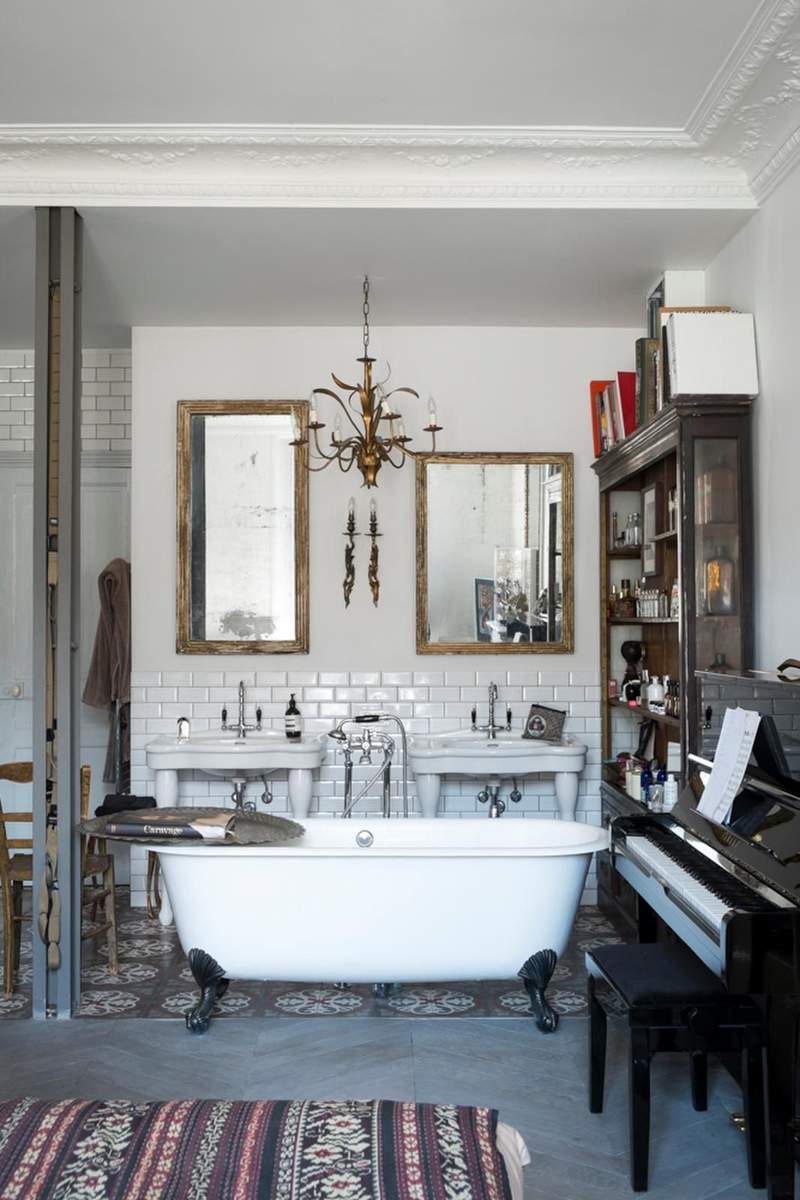 Elegant bathroom with an oval beveled mirror, marble countertop, and nickel hardware.