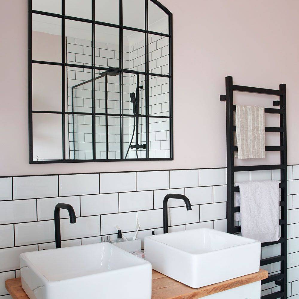Spa bathroom with a mirror built into a tiled wall niche, slate tiles, and warm lighting.