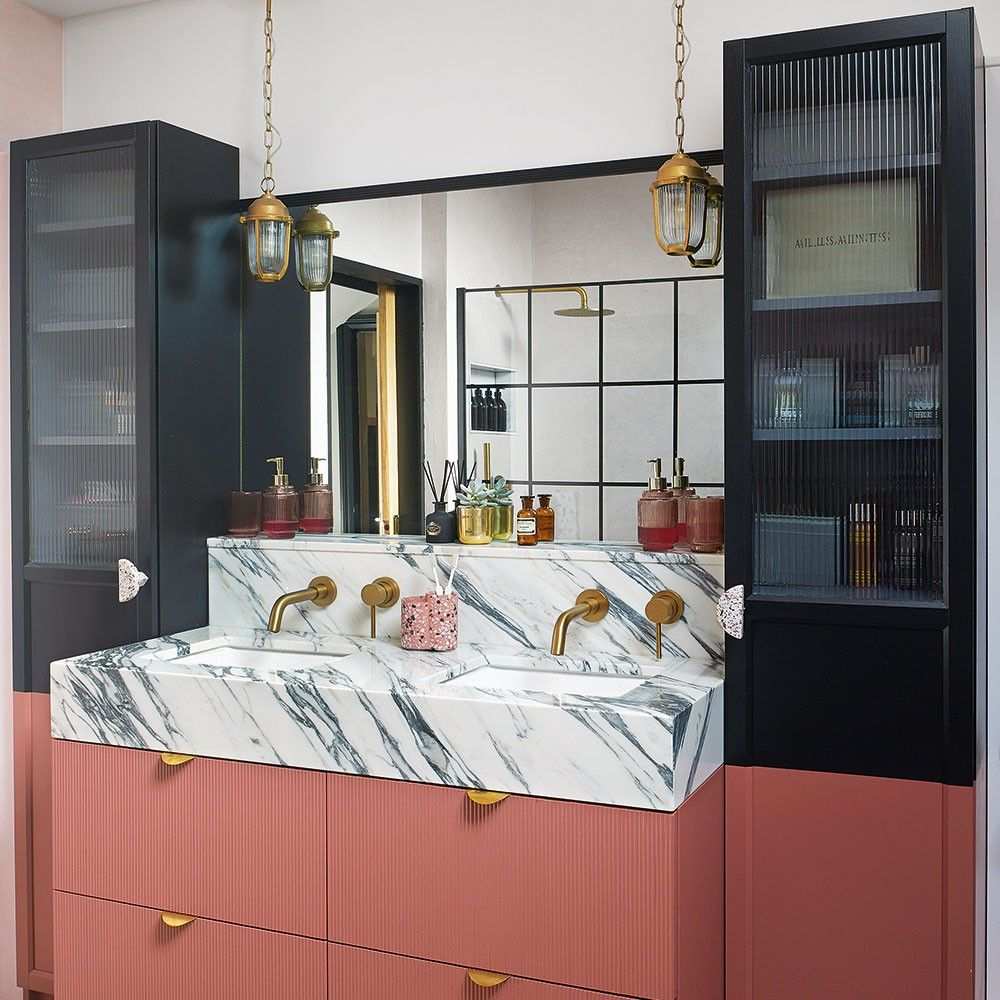 Mediterranean bathroom with a hammered copper mirror, terracotta tiles, and turquoise accents.