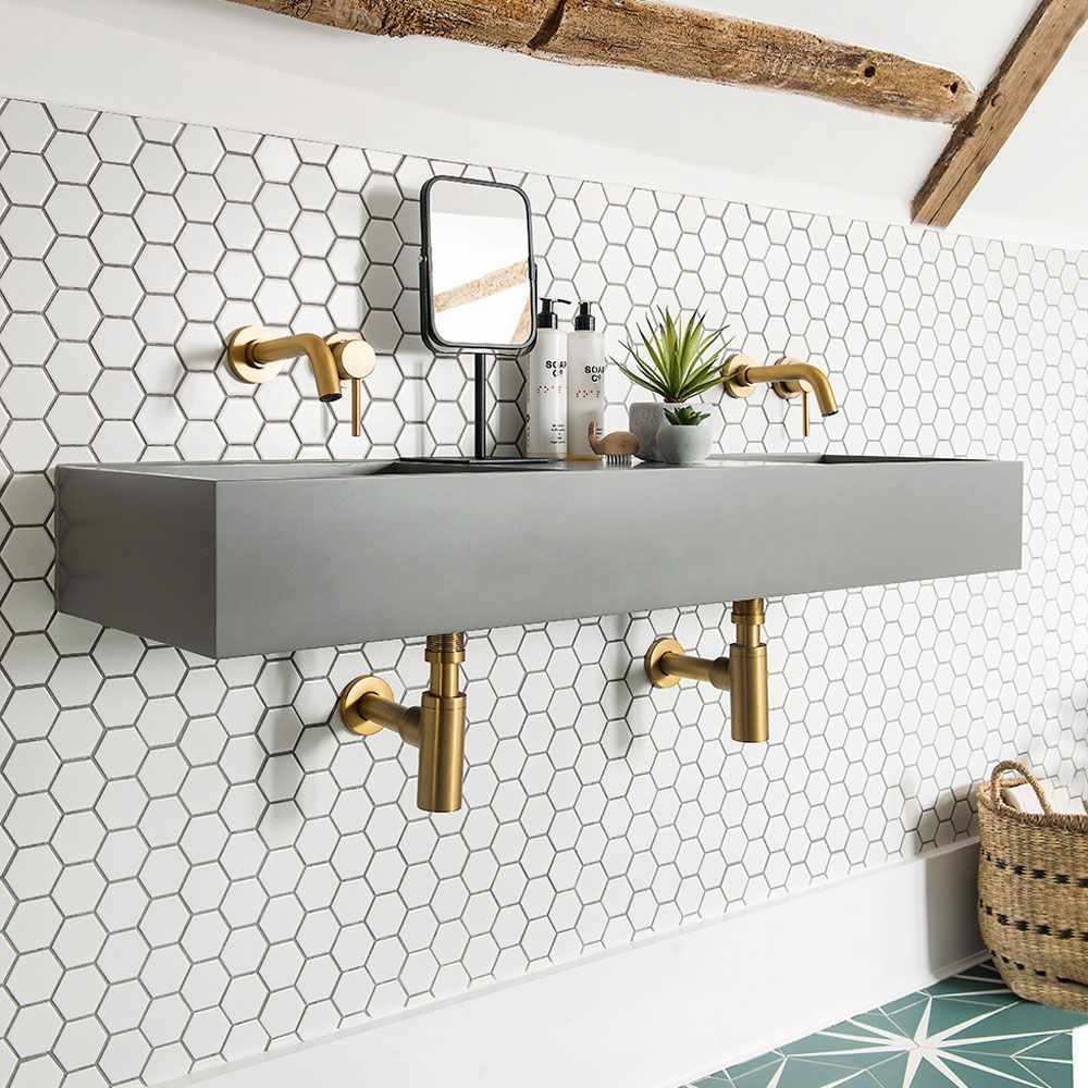 Modern master bath with an edge-to-edge mirror, stone countertop, and pendant lighting.