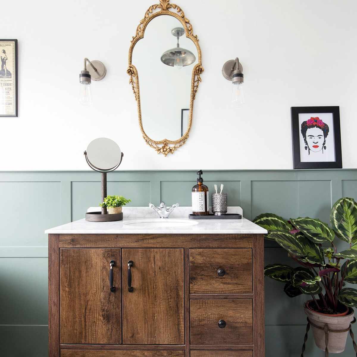 A stunning arched bathroom mirror with a slim brushed brass frame above a marble vanity.