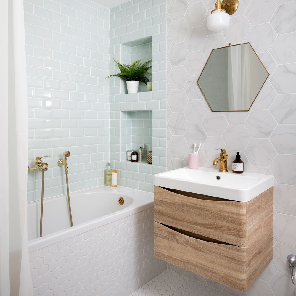 A sleek circular bathroom mirror floating above a floating wooden vanity in a modern bathroom.