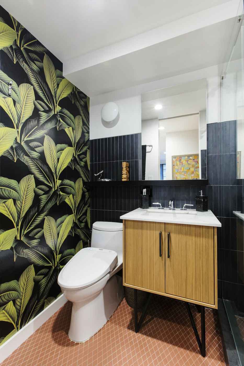 Dark bathroom featuring black botanical wallpaper matte black fixtures marble basin soft pendant light.