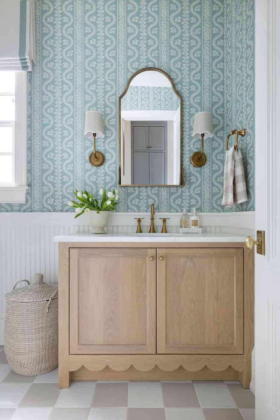 Contemporary bathroom with blue patterned geometric wallpaper white sink console soft wall light.