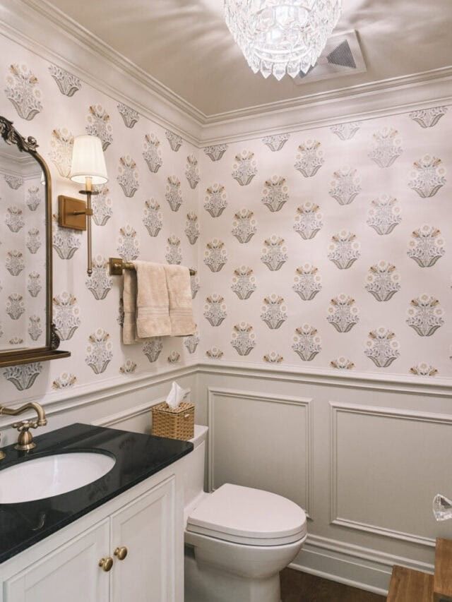 Elegant gray patterned wallpaper focused on the toilet wall with gold accessories.