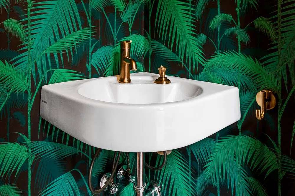 Elegant green palm leaf wallpaper in a bright, airy bathroom with white vanity.