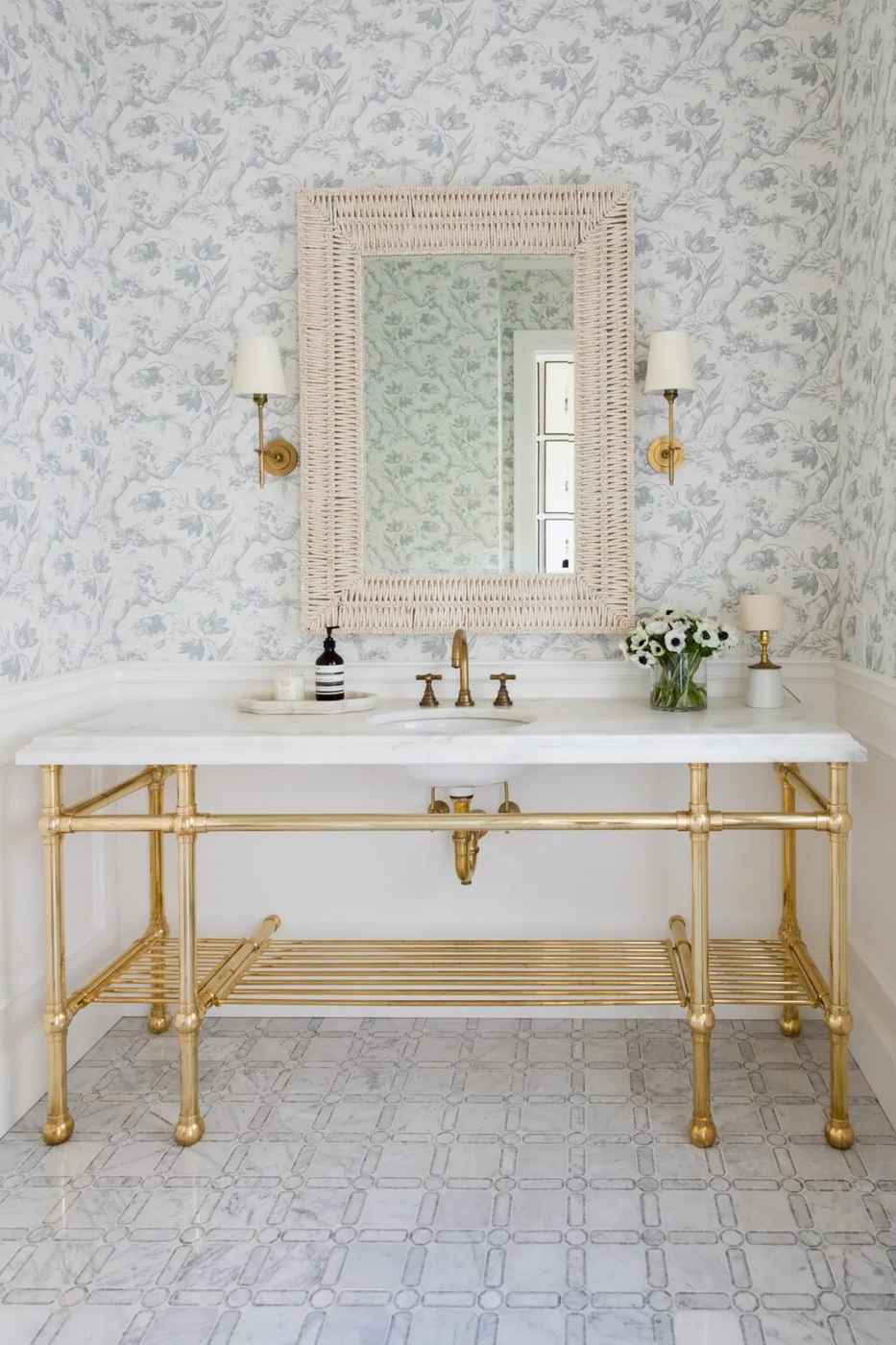 Botanical wallpaper paired with a marble vanity and gold fixtures in a luxury bathroom.