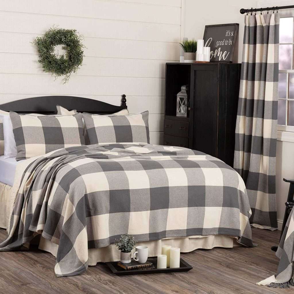 Contemporary hotel bedroom featuring crisp white percale bedding with black contrast piping and soft lighting.
