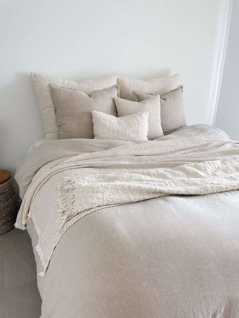 Modern master bedroom featuring navy velvet duvet set, champagne silk pillows, ambient sconce illumination.