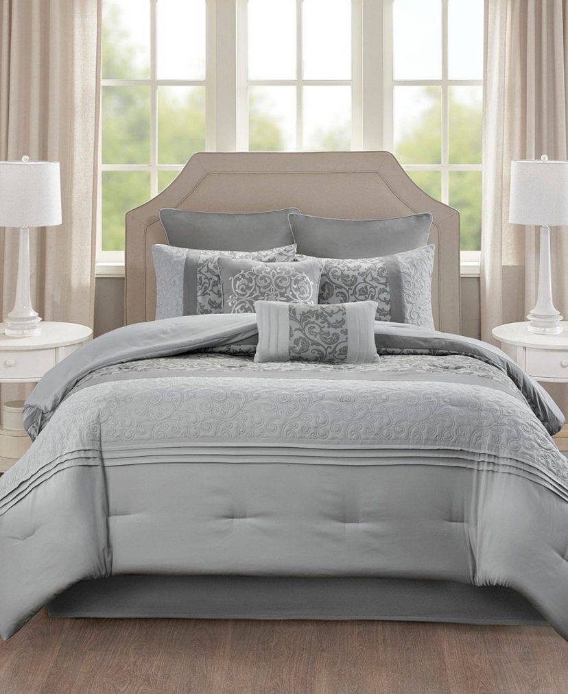 Coastal bedroom with bleached oak bed, blue ticking stripe linen bedding, bright natural window light.