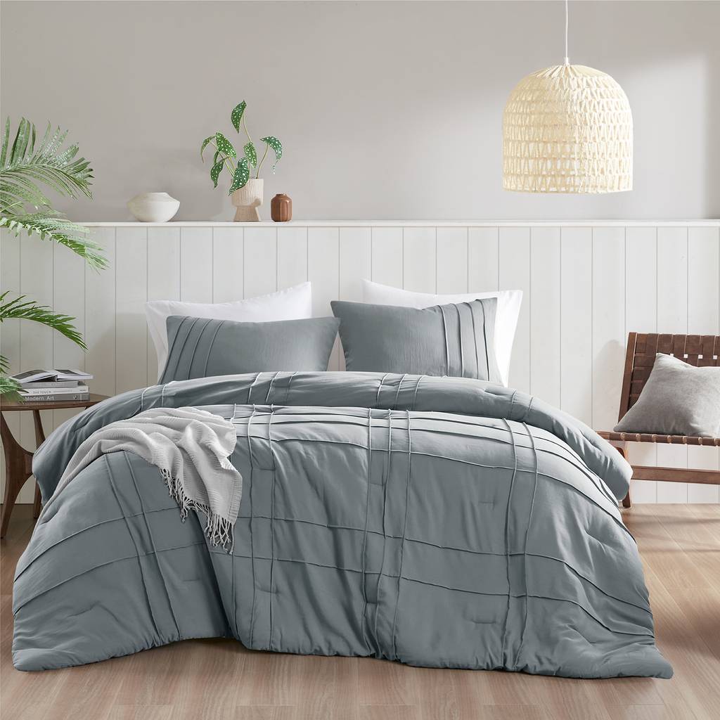 Contemporary bedroom with dark walnut headboard, forest green waffle bedding set, dim warm sconce lighting.