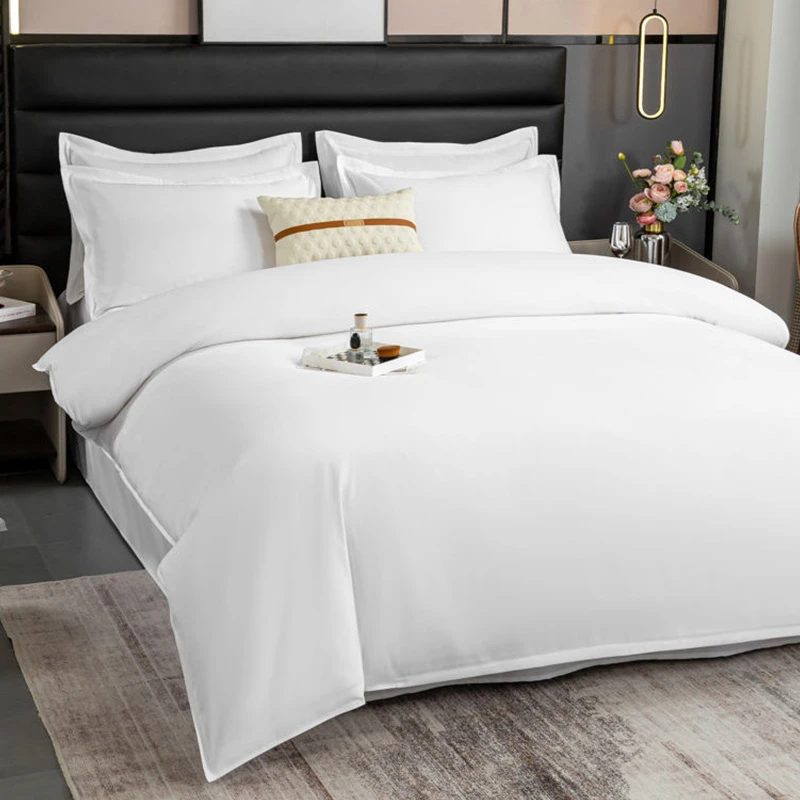 Elegant French country bedroom with cream ruffled bedding set, carved wood bed frame, soft bedside lighting.