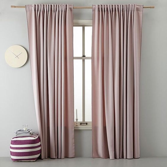 Soft blue linen curtains in a coastal bedroom with white shiplap walls and drift wood accents.