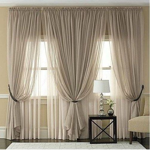 Charcoal grey grommet curtains on a black metal rod in an industrial-style bedroom.