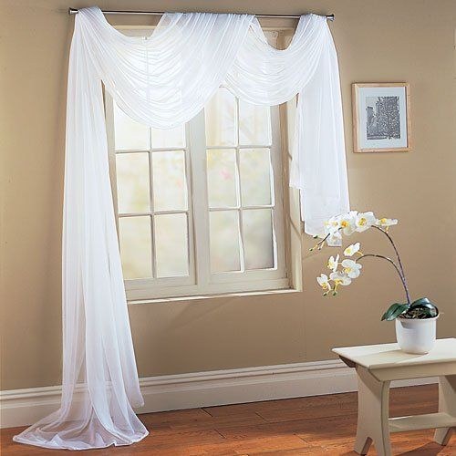 Champagne-colored silk curtains in a luxury bedroom with crystal lamps and velvet bedding.