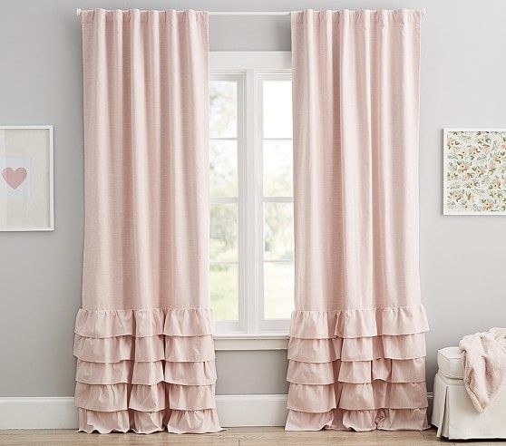 Curtains draped to one side with a sheer layer underneath in a stylish modern bedroom.