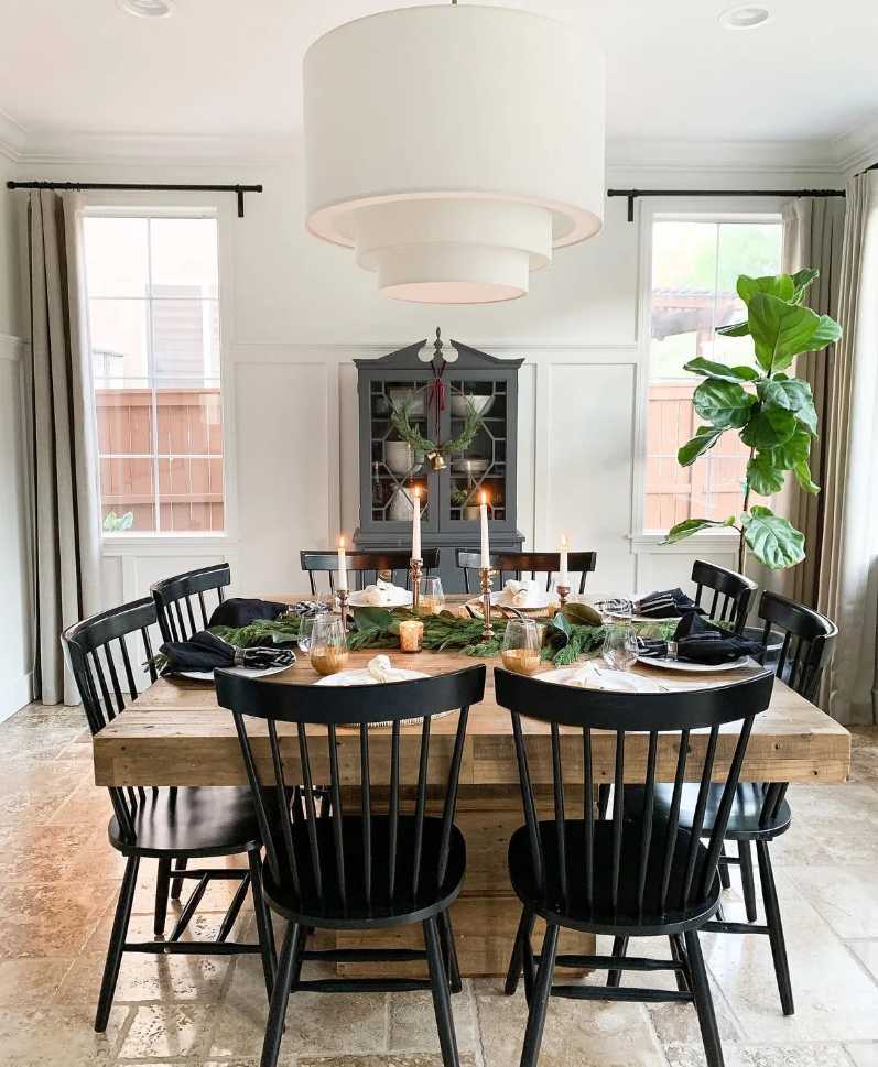 Dining area, black spindle chairs, eucalyptus garland, pastel green candles, brushed brass accents