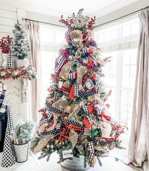 Modern living room tree with black and white striped ribbon, charcoal sofa, warm lighting