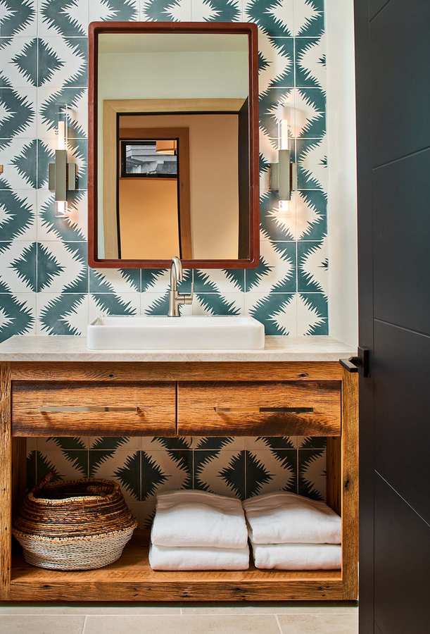 Blue diamond pattern wallpaper paired with a natural wood vanity and matte black fixtures