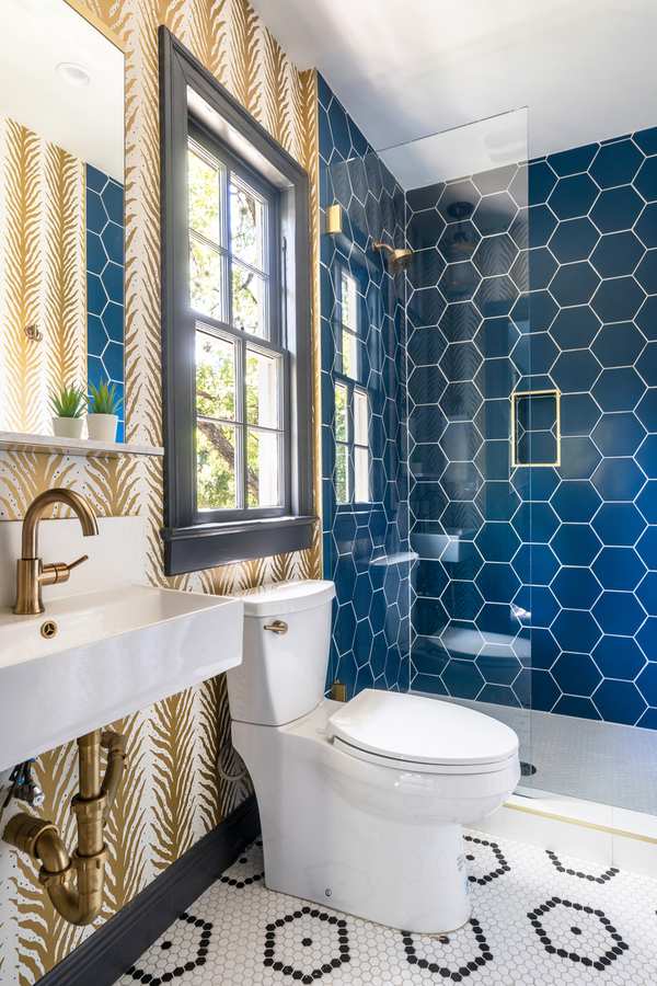 Deep ocean blue hexagon tile shower featuring matte black hardware and frameless glass door enclosure