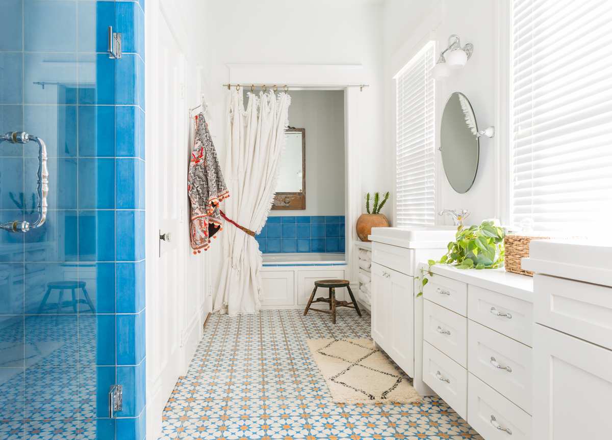 Sky blue vertical subway tile shower combined with a floating white vanity and polished chrome fixtures