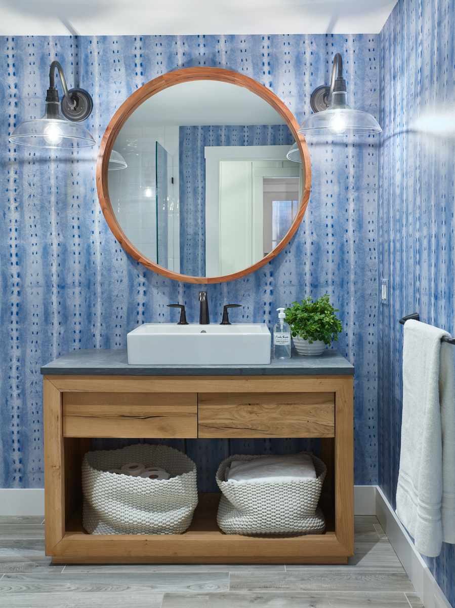 Classic blue striped wall covering complemented by a walnut wood vanity with white marble countertop