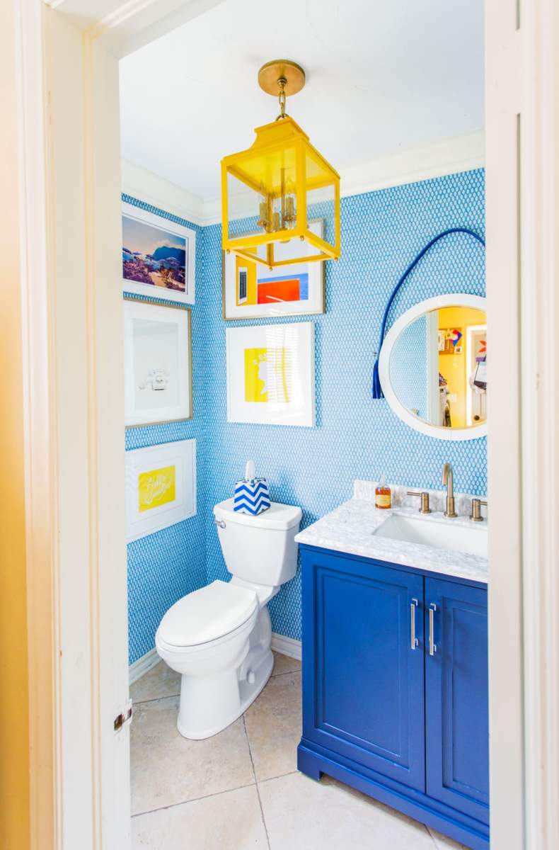 Cerulean blue painted walls highlighted by a mustard yellow blown glass pendant light and wood trim