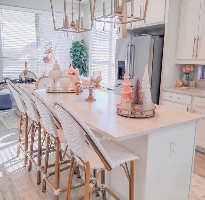 Blush and gold bottle brush tree on a sideboard with elegant ornaments.