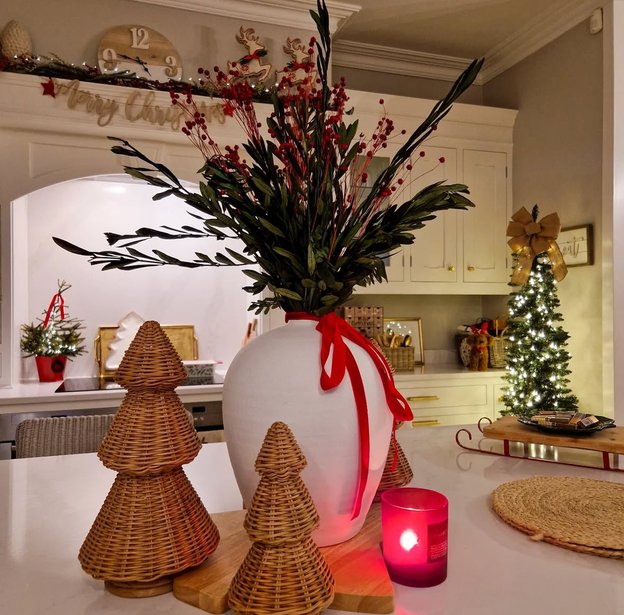Large red satin ribbon wrapped around the base of a white kitchen island.